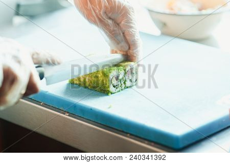Professional Chef, Chef The Process Of Making Sushi Rolls, Spins Bamboo Mat And Cut Slices