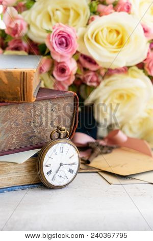 Apile Of Books With Freah Flowers On White Wooden Table