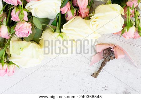 Pink And White Blooming Roses With Sceleton Key, Copy Space On Wooden Table