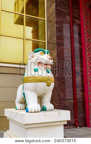 Tibetan Snow Lion With Turquoise Mane In Front Of Entrance To Buddhist Temple. Symbol Of Snow Himala