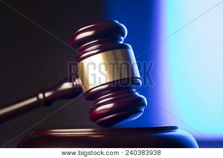 Law Theme. Mallet Of The Judge On Wooden Desk And Blue Background. Place Fort Ext.