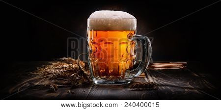 Beer In Mug And Wheet On Wooden Table And Black Background