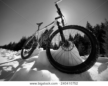 Mountain Bike Standing In Frozen Snow Against Blue Sky. Hidden  Asphalt Road Under Sow Cover. Extrem