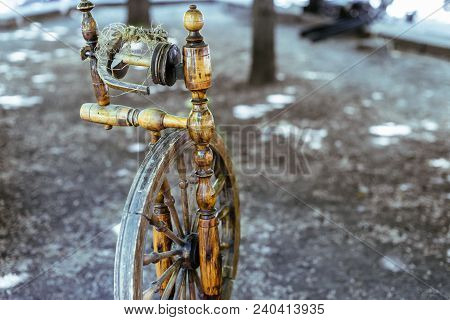 Old Spinning Wheel Stands In The Shade Of The Trees
