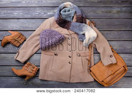 Flat Lay Women Autumn Outfit. Female Topcoat, Boots And Accessories On Old Wooden Background. Femini