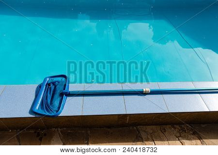 Cleaning Tool Lay On Blue Swimming Pool Outdoors