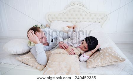 Young Man And Woman Sleeping In Bed On Pilllows In Morning. Concept Of Rsting On Weekends In Bedroom