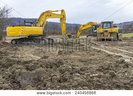 Two Excavators At A Loamy Construction Site