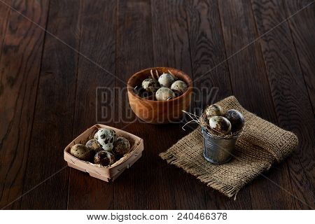 Rustic Still Life With Fresh Quail Eggs In Decorative Metal Bucket With Some Hay, Wooden Bowl And Bo