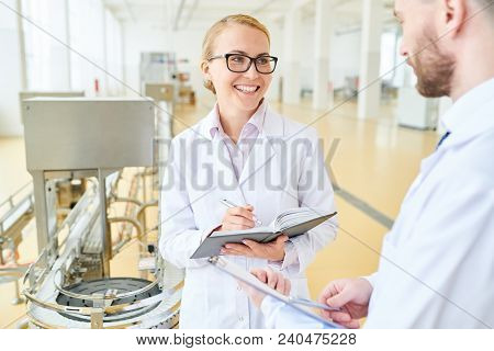 Portrait Shot Of Attractive Technologist With Charming Smile Talking To Male Colleague And Taking No