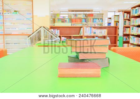 Old Book And Heap Treatise In School Library On Table Green. Blurry Bookshelves Background. Educatio
