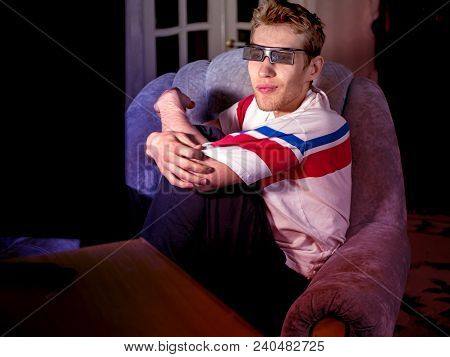 Young Man Sitting On The Sofa Wathing Tv Film At Home Using 3d Glasses