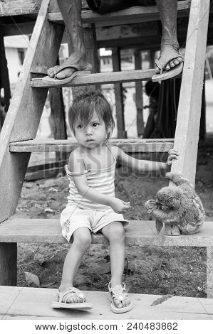 Boca De Valeria, Brazil - December 03, 2015: Child Feeding Sloth With Green Leaves On Wooden Stairs.