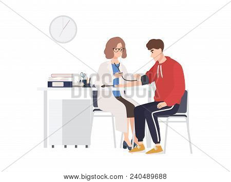 Female Doctor Or Medical Adviser Sits At Desk And Measures Blood Pressure Of Male Patient. Man At Ph
