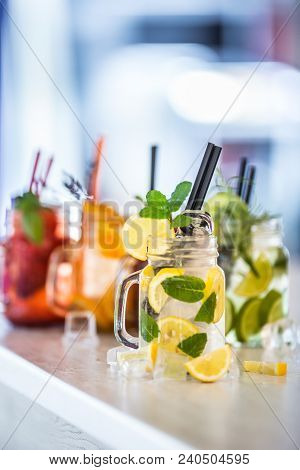 Various Lemonades In Mason Jars With Orange Lime Lemon Otange Strawberries And Fresh Fruit Fruits