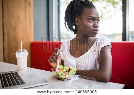 Beautiful Woman Have Lanch Eat Salad At Dinner Sitting At Cafe. Young African American Woman Sitting