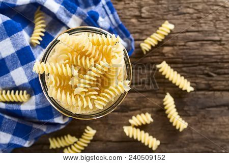 Raw Rotini Or Fusilli Pasta In Glass Jar, Photographed Overhead On Rustic Wood (selective Focus, Foc