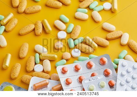 Pills And Capsules. Pile Of White Capsules And Redish Tablets Used As Medication Or Supplements