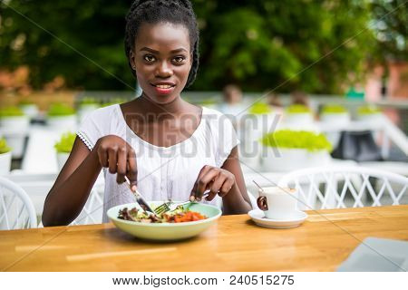 Young Afro American Woman Sitting In Street Cafe Outdoors Eat Fresh Salad