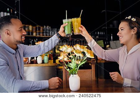 Black American Couple Talks And Drinks, Fresh Juice At A Cafe