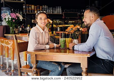 Black American Couple Talks And Drinks, Fresh Juice At A Cafe
