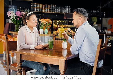 Black American Couple Talks And Drinks, Fresh Juice At A Cafe