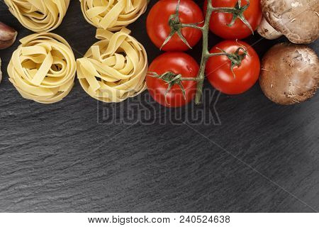 Raw Spaghetti Nest. Italian Pasta Tagliatelle With Vegetables On Slate. Traditional Italian Cuisine.