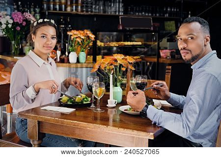 Black American Male And Female Eating Vegan Food In A Restaurant.