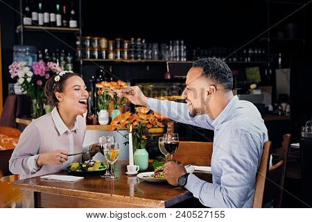 Black American Male And Female Eating Vegan Food In A Restaurant.