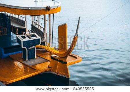 The Tiller Of The Colorful Wooden Fishing Boat And The Ocean On The Right; An Empty Nautical Vessel 