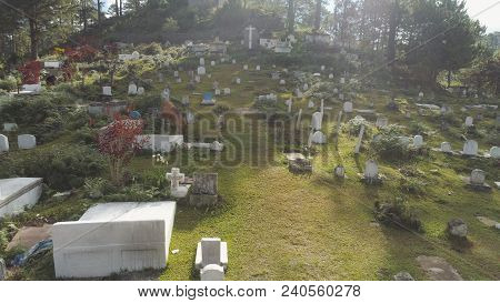 Aerial View Of Catholic Cemetery With White Tombstones, Graves And Crosses In The Mountain Province 