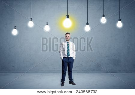 Handsome businessman in an empty space with bulbs above and uninspired face