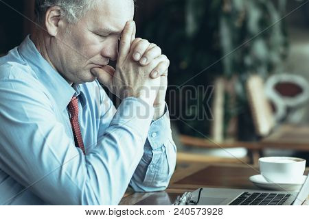 Closeup Portrait Of Middle-aged Business Man Closing Eyes, Touching Face With Hands Clasped, Thinkin