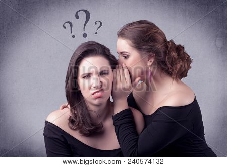A teenager girl looking confused with drawn question marks above the head, while a girlfriend whispers something in her ear concept.