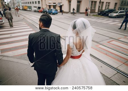 The Stylish And Elegant Bridegroom And His Pretty Wife Wallking In A City