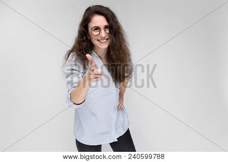 Young Girl With Glasses On A Gray Background. Portrait Of A Young Beautiful Girl. A Charming Girl In