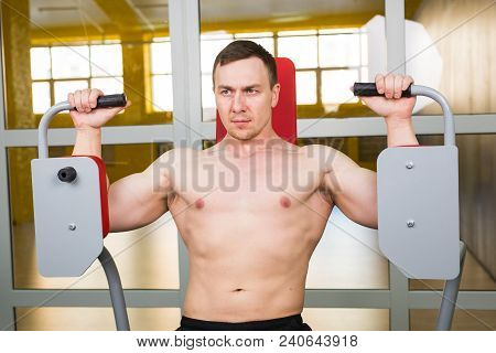 Mixed Race Man Is Working Out On Butterfly Machine In Gym.