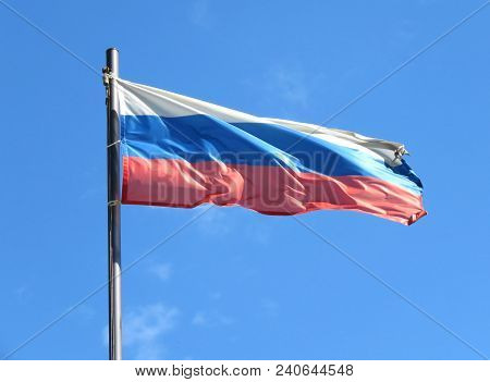 National Flag Of Russia On A Flagpole In Front Of Blue Sky.