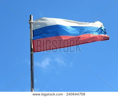 National Flag Of Russia On A Flagpole In Front Of Blue Sky.