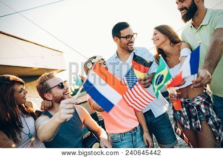 Group Of People Holding National Flags And Having Fun On Rooftop