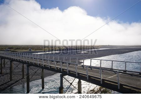 A Narrow Road Bridge Crossing A River In The Southern Alps Of New Zealand. Taken From The Tranzalpin