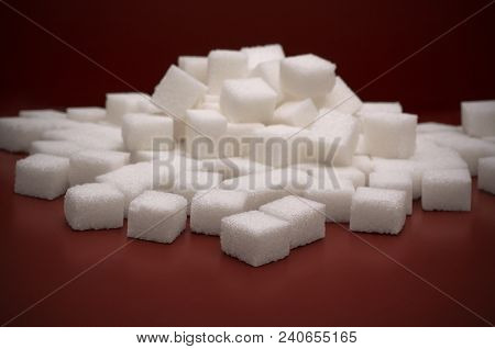 Pile Of White Sugar Cobes On Red Background