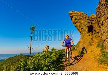 Mountain biking woman riding on bike in summer mountains forest landscape. Woman cycling MTB flow trail track. Outdoor sport activity.