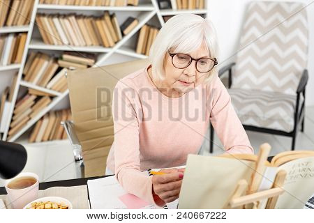 Difficult Learning. Beautiful Senior Woman Studying While Examining Book