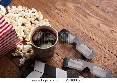 Cinema Background. Clapperboard, Popcorn, Soda Glasses And Film Reel On Wooden Table, Copy Space. Mo