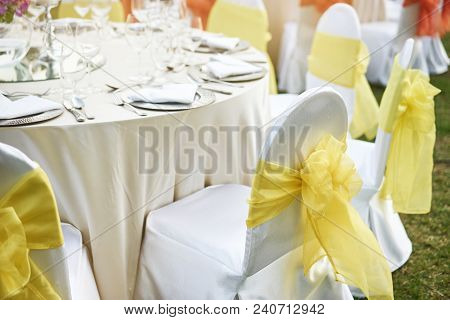 The Wedding Reception Dinner Table With Spandex White Cover Chairs With Yellow Organza Sash