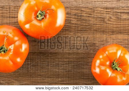 Three Red Tomato Top View Isolated On Brown Wood Background