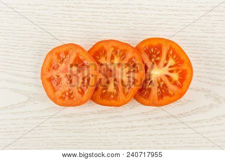 Three Red Tomato Slices Top View Isolated On Grey Wood Background Cut In Circles