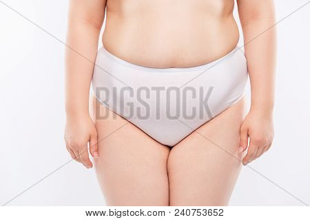 Concept Of Intimate Woman's Life. Cropped Close Up Photo Of Chummy Fatty Woman's Lower Body, Wearing
