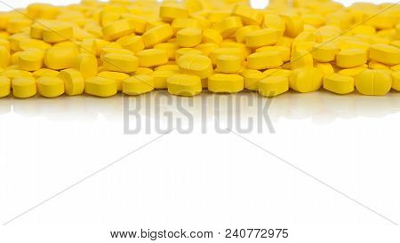 Pile Of Yellow Ovoid-rectangular Shape Tablet Pills Isolated On White Background With Copy Space. Me